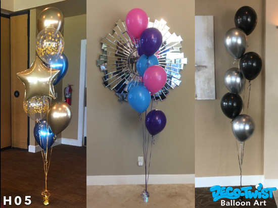 This image shows three sets of helium balloon bouquets: On the left, a bouquet of metallic gold, blue, and transparent balloons with gold confetti inside, along with a gold star-shaped balloon. In the middle, a bouquet of round balloons in pink, blue, and purple, placed in front of a decorative mirror. On the right, a bouquet of black and silver balloons arranged in a vertical cluster against a neutral wall. Each bouquet is tethered to a weight at the bottom to keep them in place.